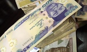 This picture taken on January 28, 2016 in Lagos shows naira banknotes, Nigeria's currency. 
Nigeria's central bank governor, Godwin Emefiele, on January 26 dismissed calls to devalue the naira in his monetary policy committee statement. Instead he chose to continue propping up the currency at 197-199 naira to the dollar and maintain foreign-exchange restrictions. As a result, the naira on the black market is hovering around a record low of 305, fuelling complaints from domestic and foreign businesses who can't access dollars required for imports.  / AFP / PIUS UTOMI EKPEI