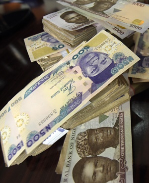 This picture taken on January 28, 2016 in Lagos shows naira banknotes, Nigeria's currency. 
Nigeria's central bank governor, Godwin Emefiele, on January 26 dismissed calls to devalue the naira in his monetary policy committee statement. Instead he chose to continue propping up the currency at 197-199 naira to the dollar and maintain foreign-exchange restrictions. As a result, the naira on the black market is hovering around a record low of 305, fuelling complaints from domestic and foreign businesses who can't access dollars required for imports.  / AFP / PIUS UTOMI EKPEI