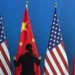FILE PHOTO - A Chinese woman adjusts a Chinese national flag next to U.S. national flags before a Strategic Dialogue expanded meeting, part of the U.S.-China Strategic and Economic Dialogue (S&ED) held at the Diaoyutai State Guesthouse in Beijing, July 10, 2014. REUTERS/Ng Han Guan/Pool