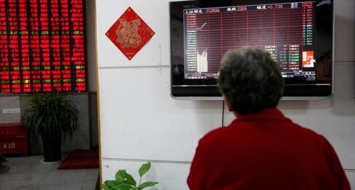 An investor looks at an electronic board showing stock information on the first trading day after the New Year holiday at a brokerage house in Shanghai, China, January 3, 2017. REUTERS/Aly Song