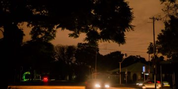 Vehicles pass on an unlit street after a load-shedding power outage in Pretoria, South Africa.  Photographer: Waldo Swiegers/Bloomberg